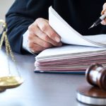 Scales of justice with judge gavel on table